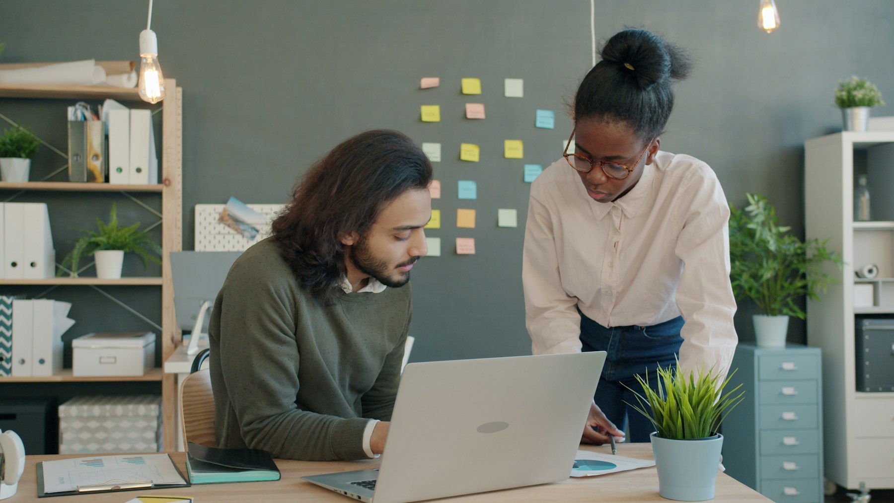 Two teammates collaborating at a laptop in an early-stage startup workspace